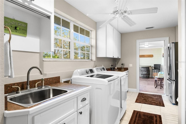 laundry area with light tile patterned flooring, sink, cabinets, washing machine and clothes dryer, and ceiling fan