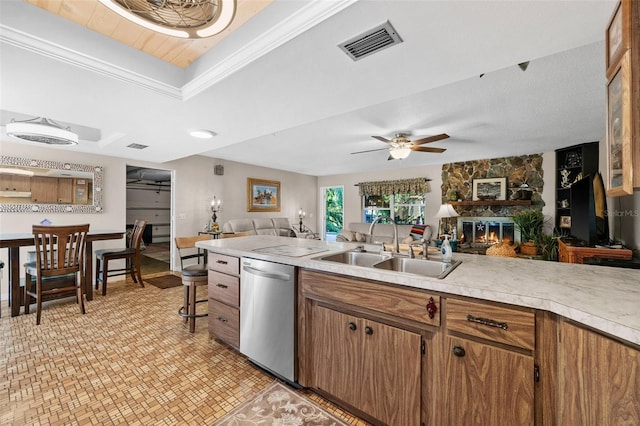 kitchen featuring sink, crown molding, dishwasher, a fireplace, and a raised ceiling