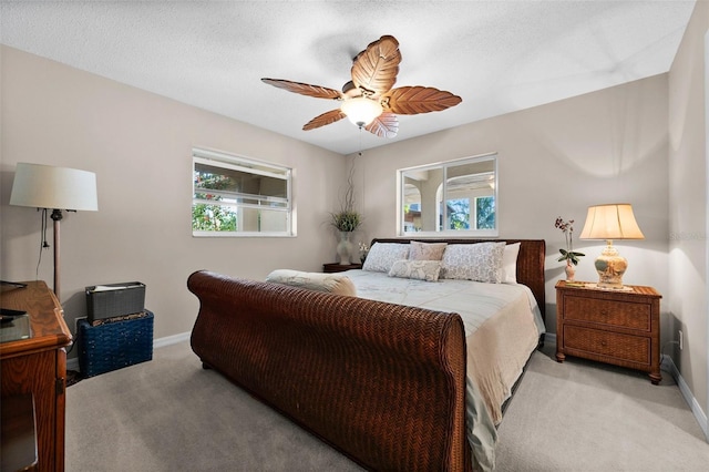 carpeted bedroom featuring ceiling fan and a textured ceiling