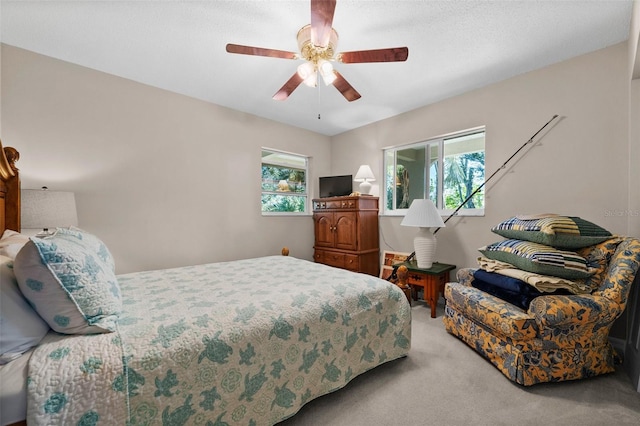 carpeted bedroom featuring ceiling fan and multiple windows