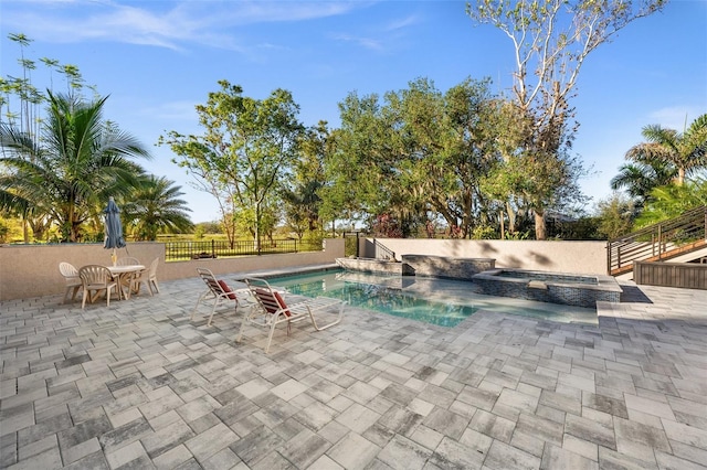 view of swimming pool featuring an in ground hot tub and a patio