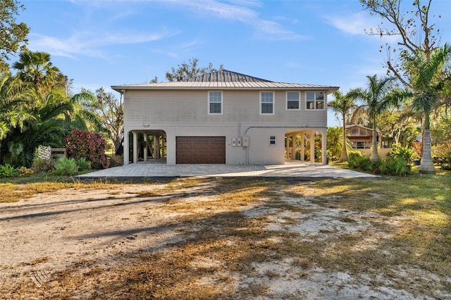 rear view of house featuring a carport and a garage