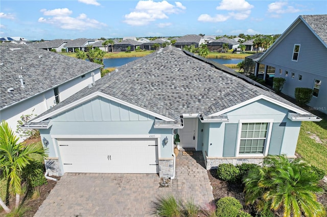 view of front of home with a garage and a water view