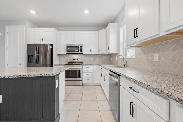 kitchen featuring white cabinetry, light stone countertops, sink, and stainless steel appliances