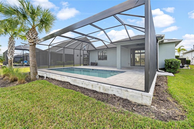 view of pool featuring a patio area, ceiling fan, a lanai, and a lawn