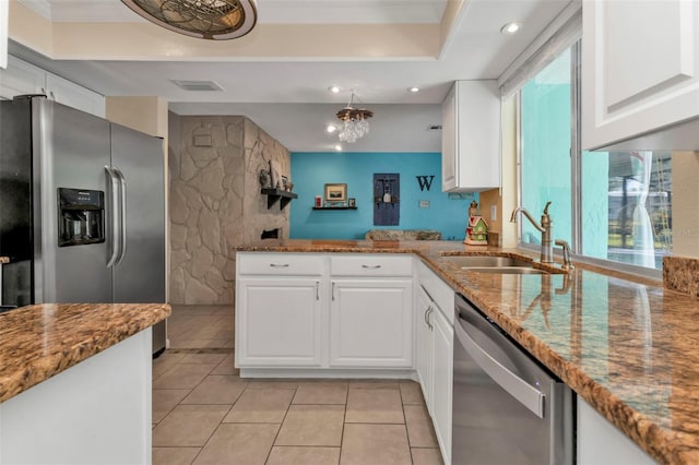 kitchen with white cabinets, stainless steel appliances, stone counters, and sink