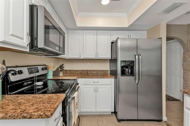 kitchen featuring appliances with stainless steel finishes, a raised ceiling, crown molding, light tile patterned floors, and white cabinetry