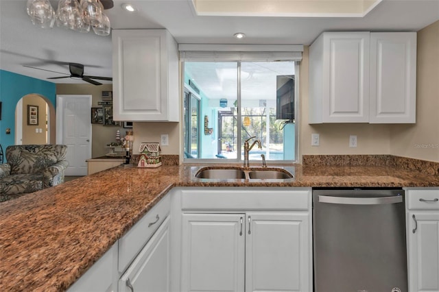 kitchen featuring dark stone countertops, dishwasher, white cabinets, and sink