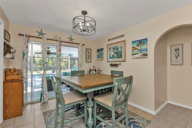 tiled dining area with a textured ceiling and a notable chandelier