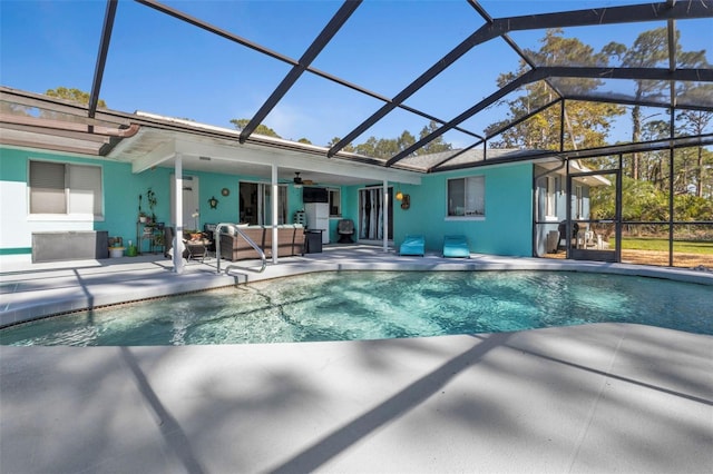 view of swimming pool with a lanai, ceiling fan, and a patio area