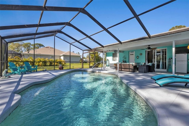 view of swimming pool featuring a lanai, outdoor lounge area, ceiling fan, and a patio area