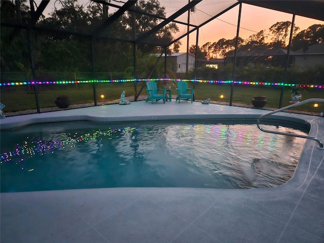 pool at dusk with a lanai and a patio area