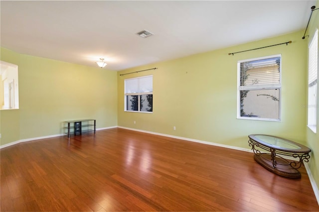 empty room with wood-type flooring and a wealth of natural light