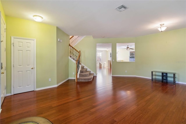 unfurnished living room featuring ceiling fan and dark wood-type flooring