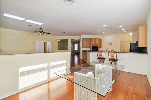 dining space featuring light hardwood / wood-style floors and ceiling fan