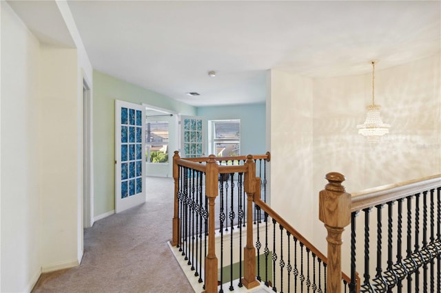 corridor featuring carpet and an inviting chandelier