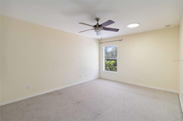 empty room featuring ceiling fan and light carpet