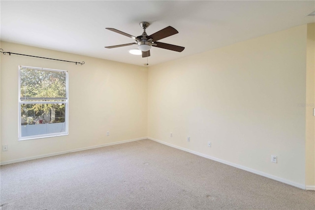 carpeted spare room featuring ceiling fan