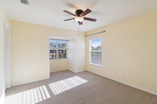 unfurnished room with light colored carpet and ceiling fan