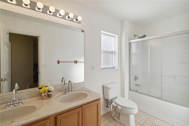 full bathroom featuring tile patterned flooring, vanity, toilet, and bath / shower combo with glass door