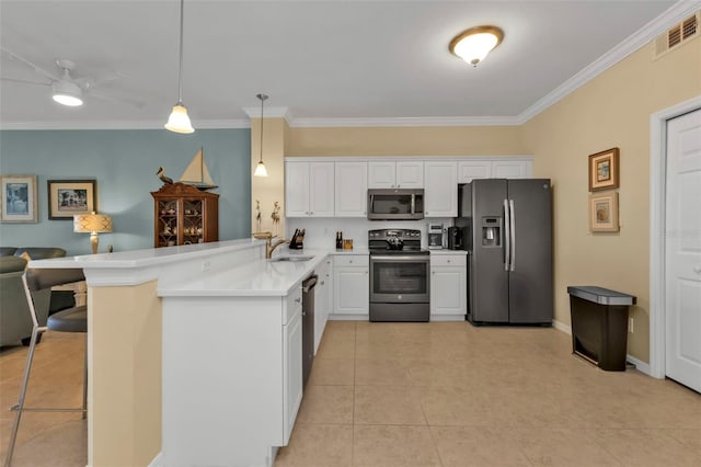 kitchen featuring kitchen peninsula, a breakfast bar, stainless steel appliances, white cabinets, and hanging light fixtures