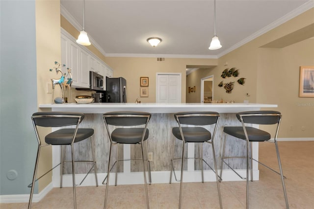 kitchen featuring ornamental molding, white cabinets, hanging light fixtures, and appliances with stainless steel finishes