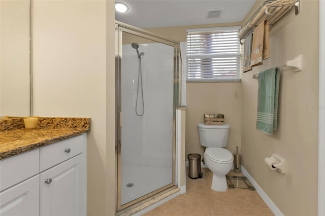 bathroom featuring toilet, a shower with door, vanity, and tile patterned flooring