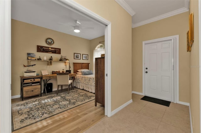 foyer with crown molding, ceiling fan, and light tile patterned flooring