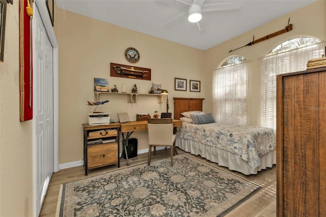 bedroom featuring ceiling fan, light wood-type flooring, and a closet