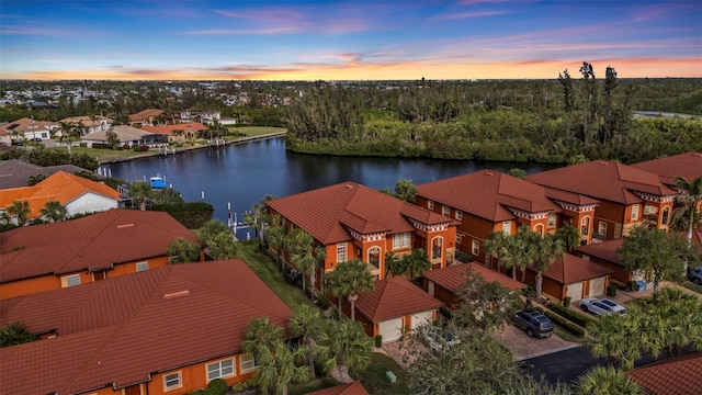 aerial view at dusk featuring a water view