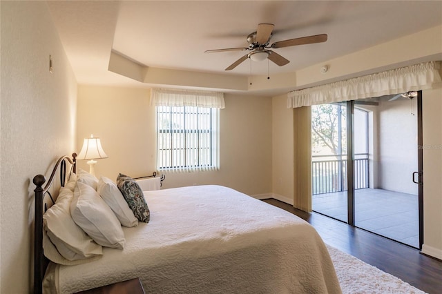 bedroom with dark hardwood / wood-style flooring, access to outside, and ceiling fan