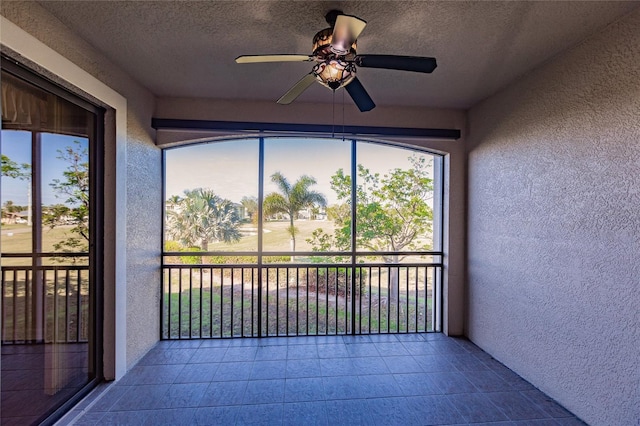 unfurnished sunroom with ceiling fan and a healthy amount of sunlight