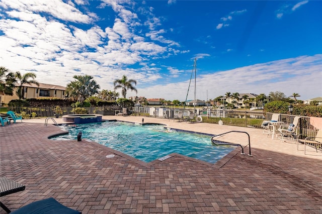 view of pool with pool water feature, a hot tub, and a patio area