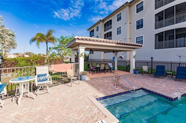 view of swimming pool with a gazebo, ceiling fan, and a patio