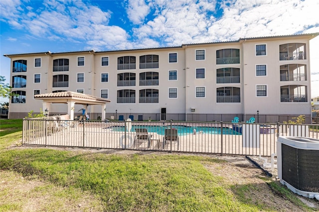 view of pool featuring a lawn, a patio area, and cooling unit