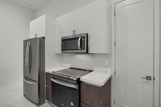 kitchen featuring tasteful backsplash, white cabinetry, dark brown cabinets, and stainless steel appliances