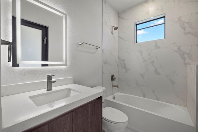 full bathroom featuring vanity, tiled shower / bath combo, and toilet