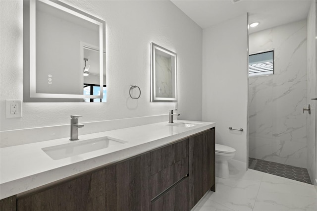 bathroom featuring tiled shower, vanity, and toilet