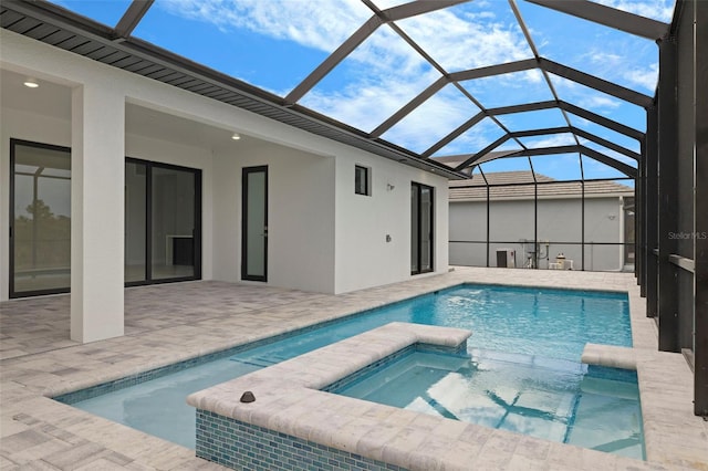 view of pool featuring a lanai, a patio area, and an in ground hot tub