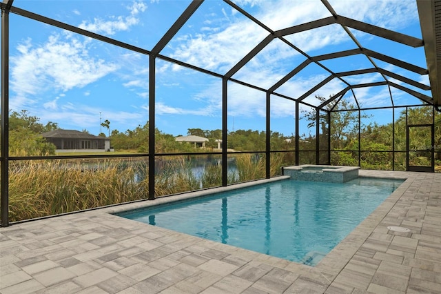 view of pool featuring glass enclosure, a water view, an in ground hot tub, and a patio