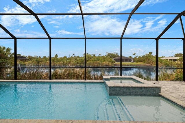 view of swimming pool with glass enclosure, an in ground hot tub, and a water view