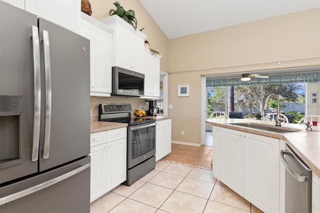 kitchen with ceiling fan, sink, vaulted ceiling, white cabinets, and appliances with stainless steel finishes