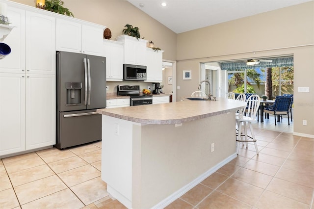 kitchen with stainless steel appliances, ceiling fan, sink, a center island with sink, and white cabinets