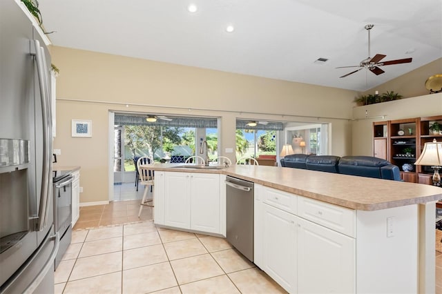 kitchen featuring stainless steel appliances, vaulted ceiling, ceiling fan, white cabinetry, and light tile patterned flooring