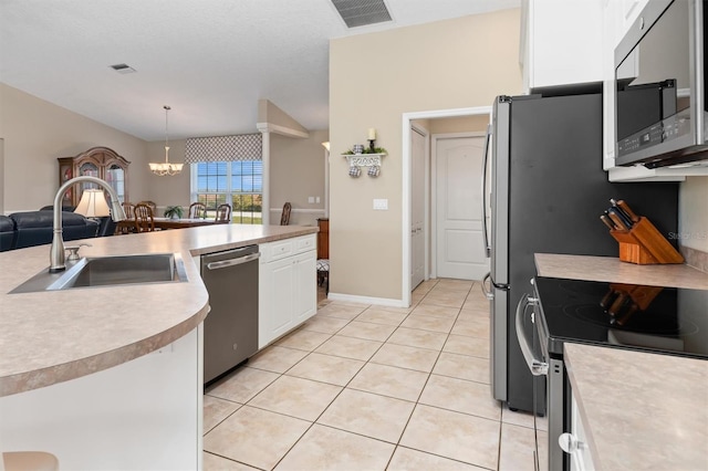 kitchen with an inviting chandelier, sink, appliances with stainless steel finishes, decorative light fixtures, and white cabinetry