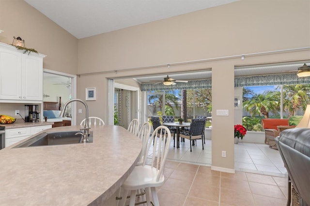 kitchen featuring a wealth of natural light, white cabinetry, sink, and light tile patterned flooring