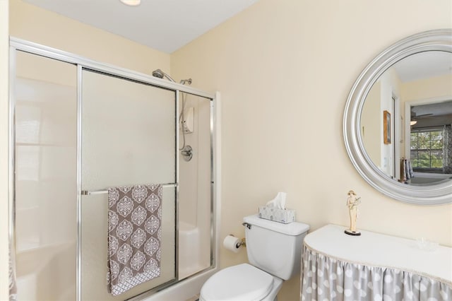 bathroom featuring toilet and a shower with shower door