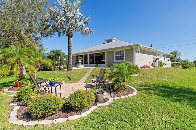 back of house with a lawn, a patio area, and a sunroom