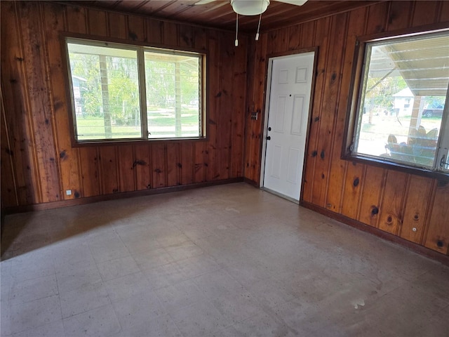 spare room featuring wood walls, plenty of natural light, and tile patterned floors