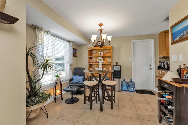 dining area featuring light tile patterned floors and an inviting chandelier